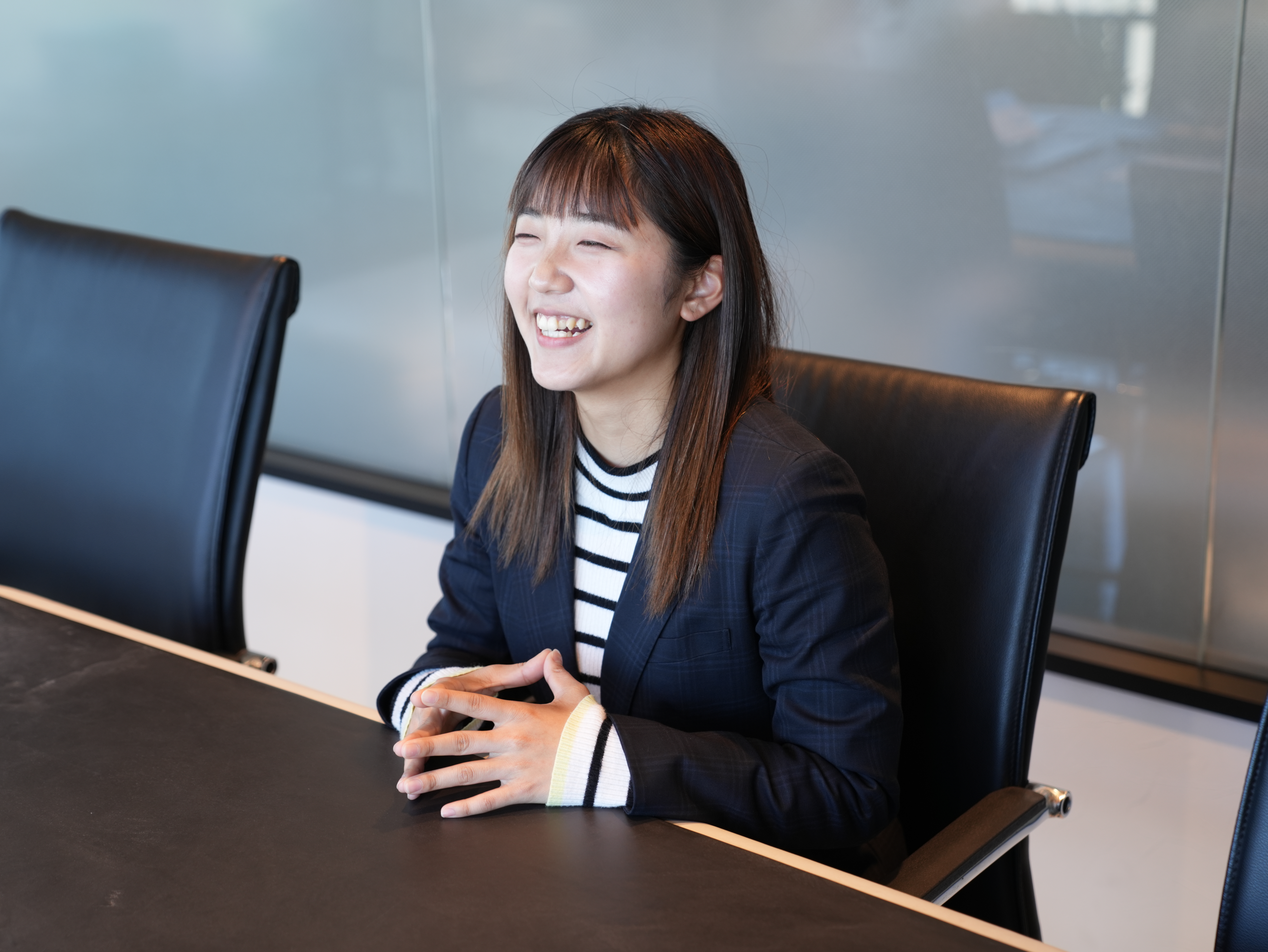 紺のスーツを着ている女性が笑っている様子